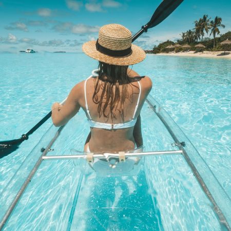 A woman kayaking in a clear transparent kayak