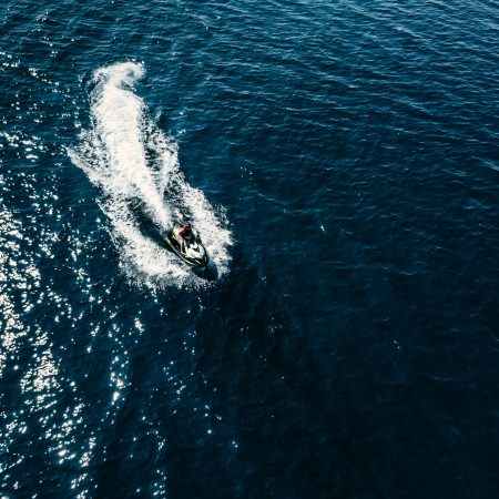 Aerial view of jet skier in blue sea. Jet ski in turquoise clear water racing