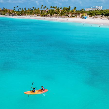 Couple Kayaking in the Ocean on Vacation Aruba Caribbean sea, man and woman mid age kayak in ocean