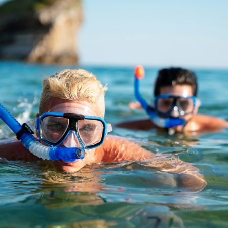 Happy friends men enjoying summer vacation and scuba diving