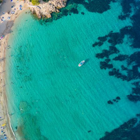 Ibiza Cala Bassa beach with turquoise water, aerial views