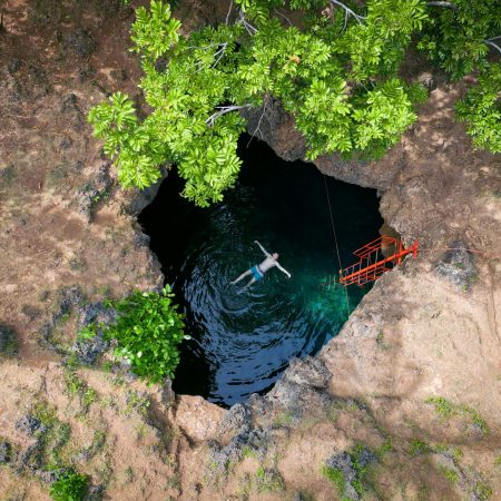 Person swimming in a Cabagnow Cave Pool, Anda, Philippines