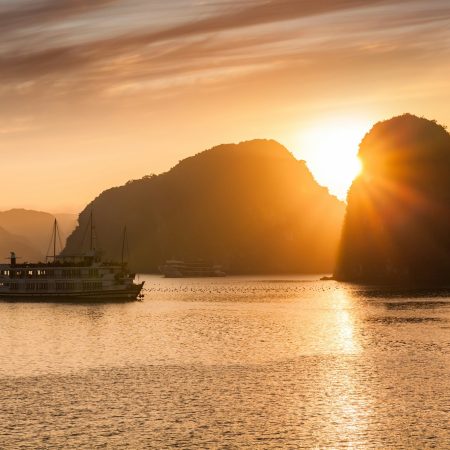 View of cruise ships and islands in Halong Bay at sunset, Vietnam